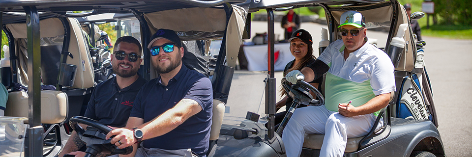 Golfers in carts lined up and ready to start the tournament.