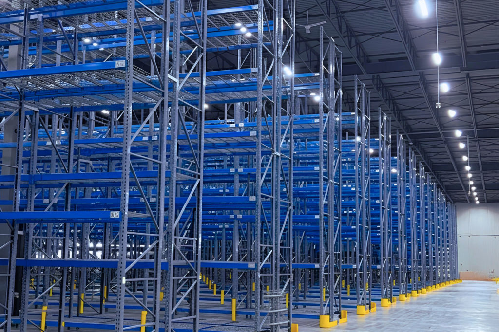 Custom selective warehouse racking solution featuring tall grey uprights, blue beams, wire decking, and yellow post protectors in a Calgary facility.